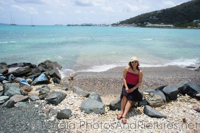 Joann sits on a rock at a rocky Tortola beach.jpg